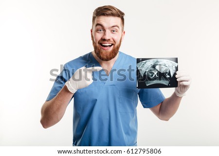 Portrait of a happy excited male medical doctor or nurse pointing finger at radiograph x-ray image isolated on white background