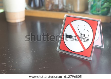 red tag no smoking sign displayed on a table in a cafe