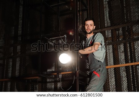 The lighting engineer adjusts the lights on stage behind the scenes
