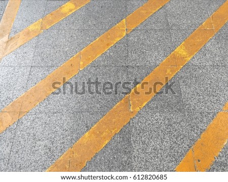 The yellow tilting line as transportation sign on cement floor