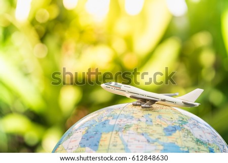 Travel and transport concept. Toy airplane on world map balloon with green nature as background. Royalty-Free Stock Photo #612848630