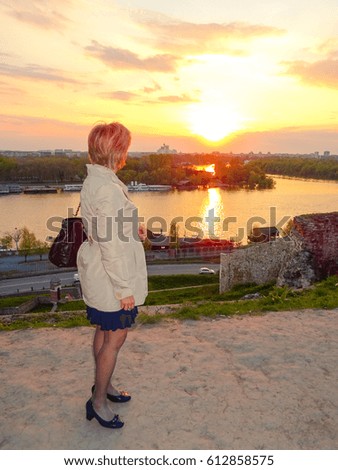Serbia, Belgrade. Picture is showing a lady watching  mouth of river Sava and Danube and city of Belgrade, in sunset. 