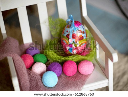 Easter egg and jewelry lie on a children's chair, waiting for a holiday