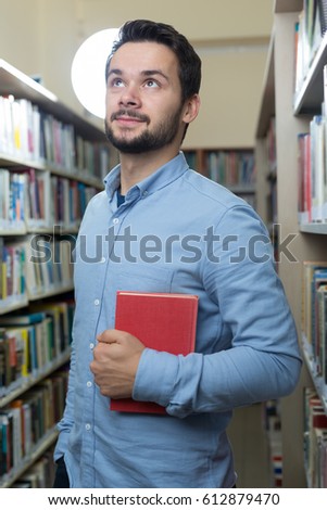 Handsome man in early 20s spending his time in library. University time 