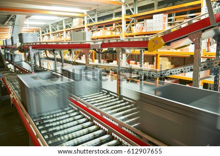 Automated warehouse. Boxes with spare parts moving on conveyer Royalty-Free Stock Photo #612907655