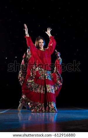 Young girl dancer and singer in gypsy dress dancing and posing on stage