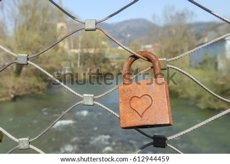old padlock hang on the bridge as a symbol of love 