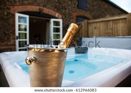 bottle of champagne cooling by hot tub 