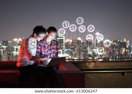 A man and woman using laptop with IOT, internet of things conceptual sign, internet era, internet in every day lifes