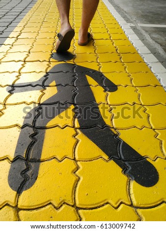 Yellow symbol Pedestrian road sign on the street