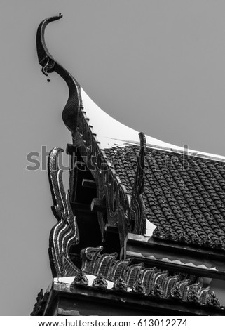 black and white picture roof's Thai temple art architecture design from old culture religion in red and gold color of great naga shape 