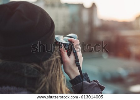 Female photographer taking photos of evening city