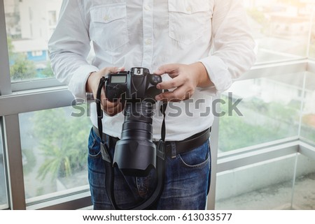 professional photographer adjusts the camera before shooting, hands, camera, background