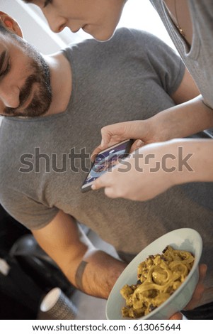 Couple taking photo of spaghetti with smart phone