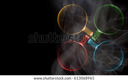 Four cups of different colors are filled with a hot drink. A thick white vapor rises above them. Illuminated upper circuit. View from above. Isolated on black. Copy space to add your text.