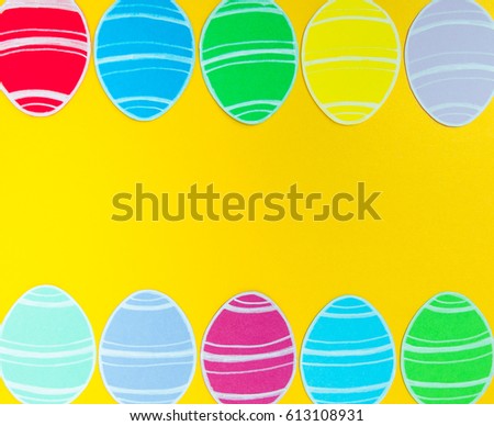 Close-up of colorful paper eggs silhouette frames against golden background