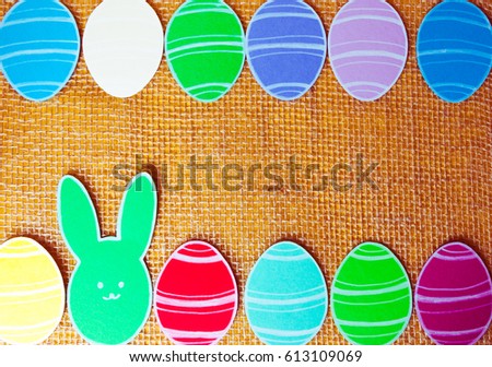 Close-up of colorful paper rabbits and paper eggs silhouette frames against canvas background