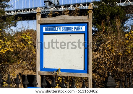 Message board with a sign depicting it is Brooklyn Bridge Park, with the Brooklyn Bridge stretching above.