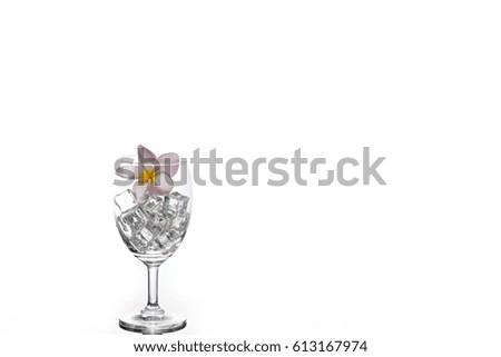 Ice and plumeria in glass wine with white background.