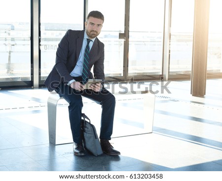 Businessman is looking at his digital tablet while is going to work