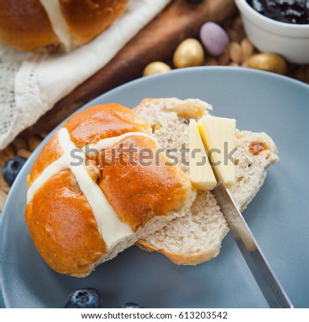 Sweet Hot Cross Bun for Easter teatime with butter -  delicious holiday treat.