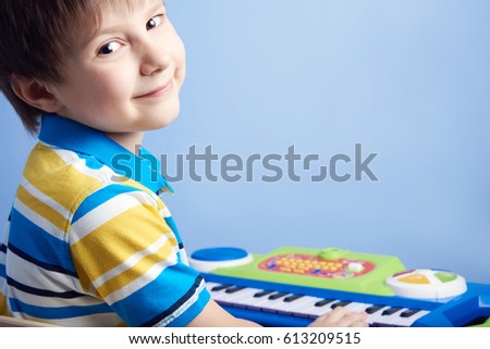 European boy playing toy piano.