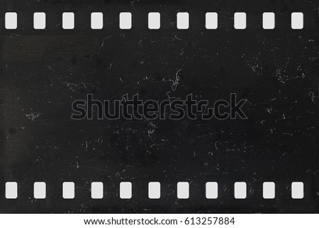 Strip of old celluloid film with dust and scratches - negative Royalty-Free Stock Photo #613257884