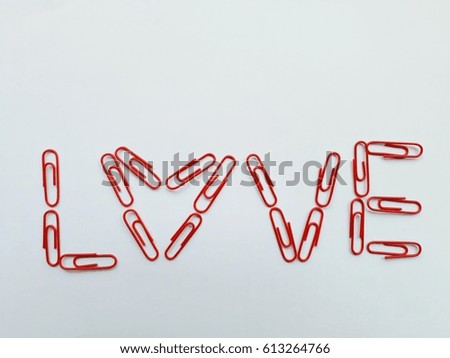 Paper clips with "LOVE" wording on white background.