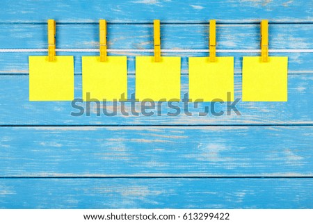 View of five clothespins hanging on a rope with five cards