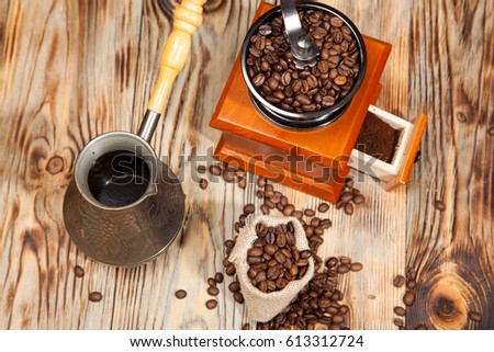 Wooden grinder with coffee beans on the tree with a bag