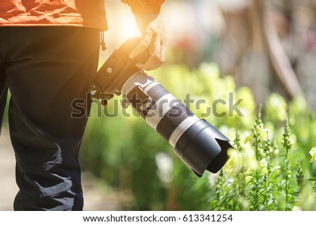 photographer man taking telephoto len in flower park