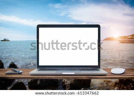 Computer notebook and mouse with a picture Sea view scenery Blur sea background sun flare effect photo