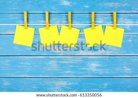 View of five yellow clothespins hanging on a rope with five cards