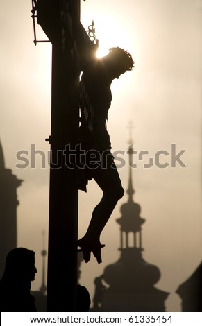 Prague - cross from H. Hilger 1629 on the charles bridge by sunrise - silhouette Royalty-Free Stock Photo #61335454