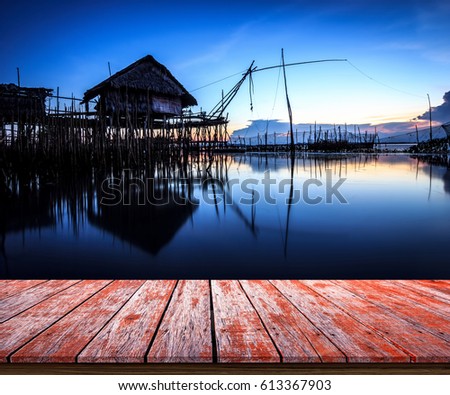Wooden deck looking out to the cottage on the water at blue sunset, soft focus background