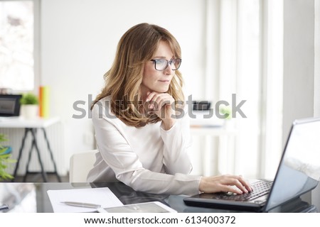 Shot of an attractive mature businesswoman working on laptop in her workstation. Royalty-Free Stock Photo #613400372