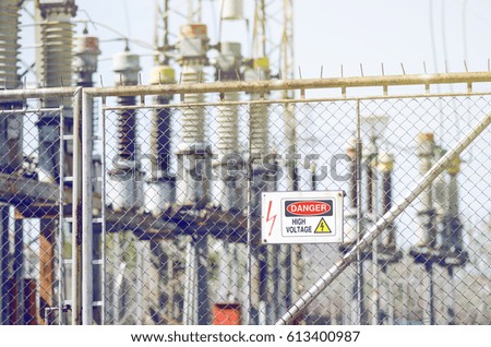 High Voltage Danger Sign With Electrical Power Devices Behind