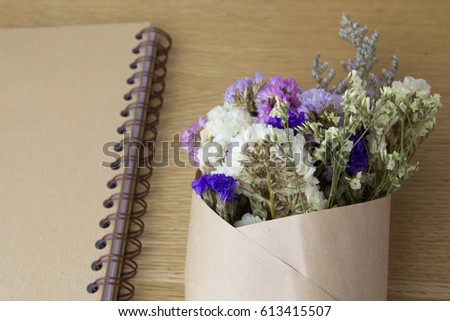 Flowers bouquet with old diary book on wood table in vintage style 