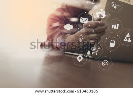 businessman working with laptop computer and document on wooden desk in modern office with virtual icons interface Royalty-Free Stock Photo #613460186