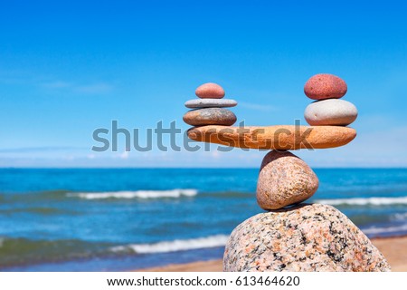Concept of harmony and balance. Balance stones against the sea. Rock zen in the form of scales Royalty-Free Stock Photo #613464620