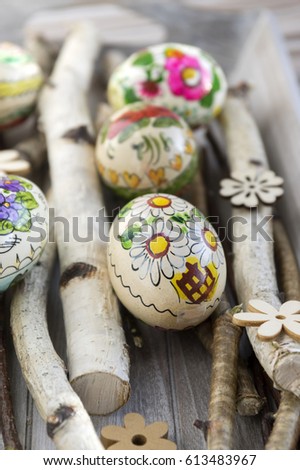 Homemade and handmade Easter eggs with flower pictures on birch branches, czech ornaments, small wooden flowers