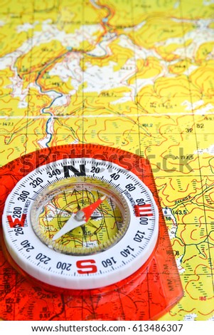 Journey into the world of adventure. Topographic map and compass on it.
