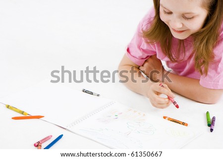 happy girl draws with crayons in the album