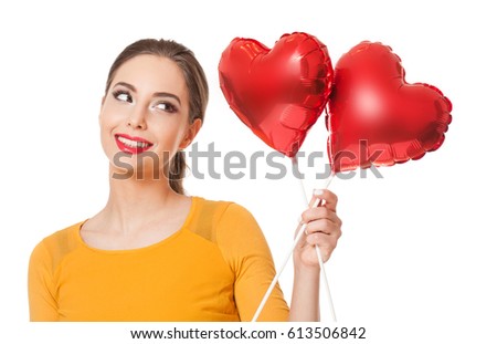 Portrait of beautiful young brunette woman with red heart shaped balloons.
