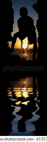 The silhouette of a young person holding the Sun.  (with water reflection)