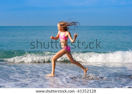 schoolgirl running on seashore