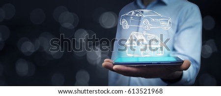man hand phone with  house and car in  screen in bokeh background