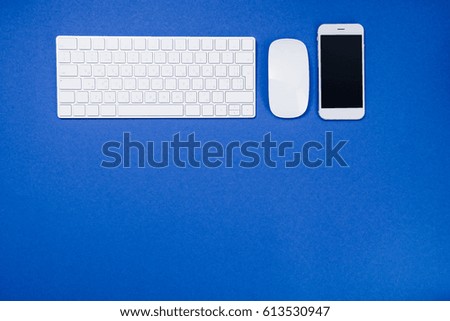 top view of digital smartphone, keyboard and computer mouse  isolated on blue