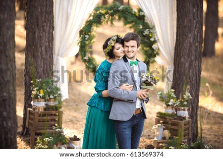Portrait of bride and groom on wedding arch background. Rustic wedding