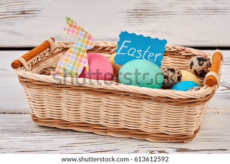 Easter basket on white wood. Greeting card and rabbit cutout.
